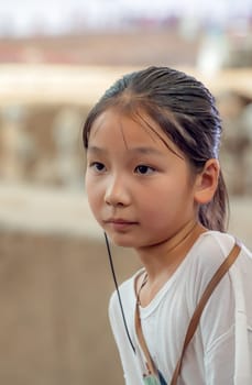 Xian, China -  July 2019 : Little chinese girl with a listening device in her ear that allows her to listen to  tour guide while visiting a museum, Shaanxi Province