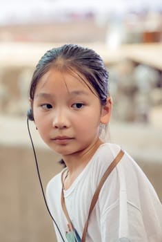 Xian, China -  July 2019 : Little chinese girl with a listening device in her ear that allows her to listen to  tour guide while visiting a museum, Shaanxi Province
