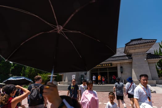 Xian, China -  July 2019 : Tourists walking on a path road leading to a museum site building containing Terracota Army sculptures, Xian, Shaanxi Province