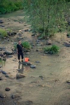 Wulingyuan, China -  August 2019 : Chinese fisherman standing in a shallow river