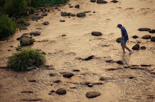 Wulingyuan, China -  August 2019 : Chinese crossing shallow river at dusk