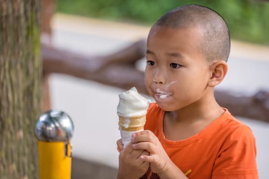 Zhangjiajie, China - August 2019 : Portrait of a young chinese boy devouring a large ice cream