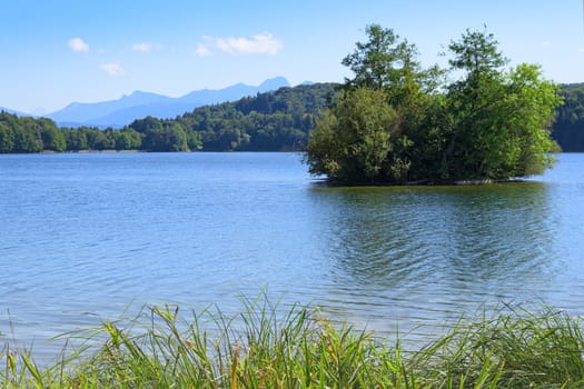 Picturesque view of small lake with wooded islet in Upper Bavaria