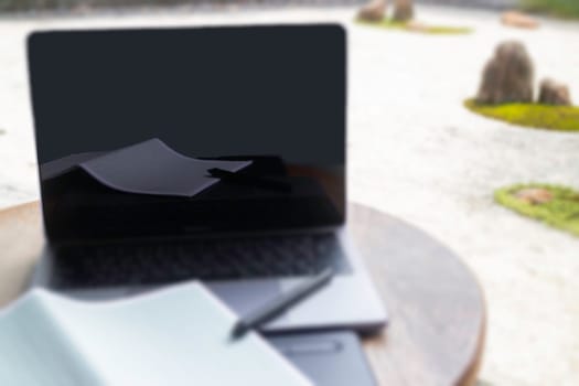 Modern laptop computer on wooden table in home garden, stock photo