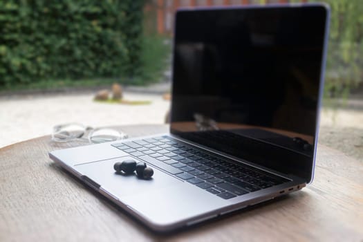 Modern laptop computer on wooden table in home garden, stock photo