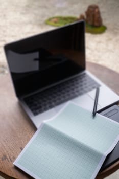 Modern laptop computer on wooden table in home garden, stock photo