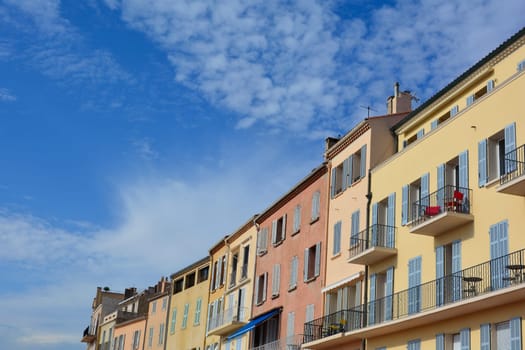 Colored house facade in the historic center of Saint Tropez, France, with balconies and many  blue sky and copy space