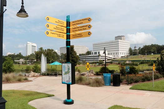 Tallahassee, FL, USA - July 15, 2018: Four-way directional sign each point to 12 local locations. Sunny Cascades park near downtown is signage that gives directions