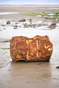 rusty metal barrel washed up on the beach