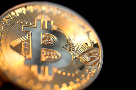 Close up of a single shiny bitcoin coin.  Wealth, digital, virtual, currency, and cryptocurrency concept.