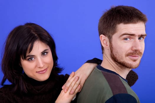 young casual couple together, isolated on blue background