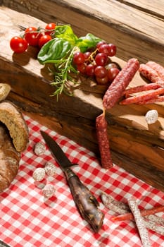Vesper,sausage plate with various salami varieties,pepper bite,kabanossi,grapes,tomatoes,basil and bread,studio