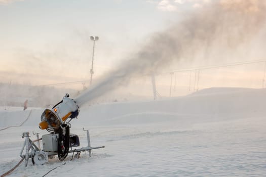 A snow blowing muchine being used to spray snow