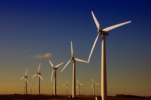 white wind turbines in the top of the mountain