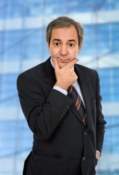 mature business man, thinking with his hand on the face