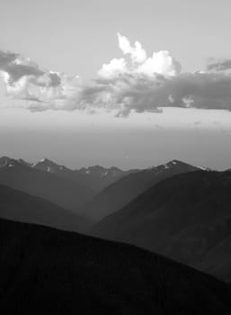 The Olumpic Mountains stand against a dramatic sky at sunrise