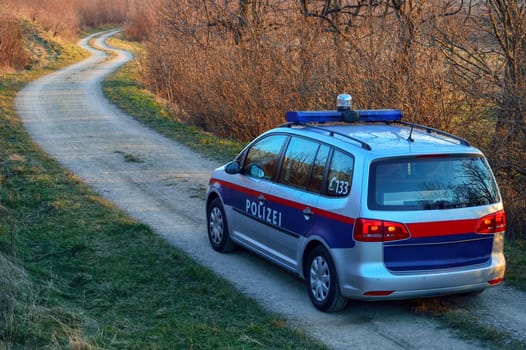 Police car sits down a path
