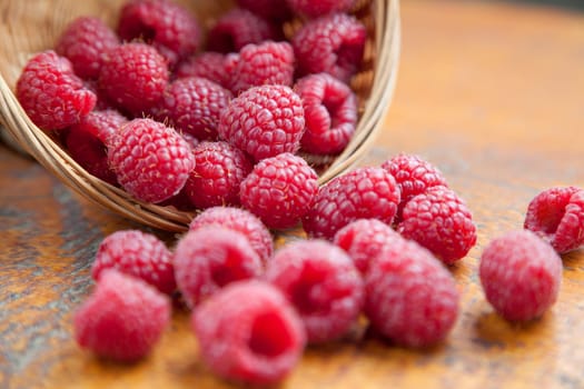 Fresh and tasty looking raspberries on a wooden table