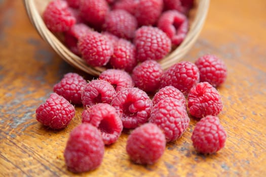 Fresh and tasty looking raspberries on a wooden table