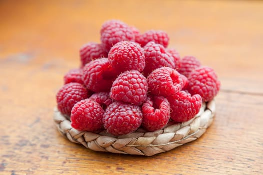 Fresh and tasty looking raspberries on a wooden table