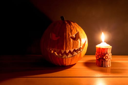 Big helloween autumn symbol with mad face, glowing eyes, mouth and teeth. Scary hot nightmare horror with evil smile at october 31st.