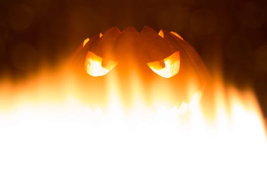 Big helloween autumn symbol with mad face, glowing eyes, mouth and teeth. Scary hot nightmare horror with evil smile at october 31st.