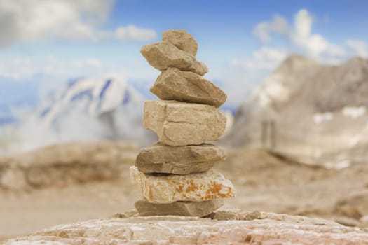 Stones stack in mountain panorama with blue sky visualizes creativity, consulting, success or showing health, meditation and therapy.