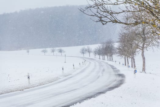The street track is slick and frozen. High dangerous risk of an accident through the blizzard snowstorm and severe weather at christmas time season.