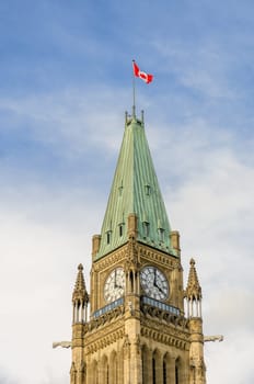 Tower of Victory and Peace of Canadian Parliament in Ottawa, Canada. Bell and Clock Tower with Canadian flag waving.
