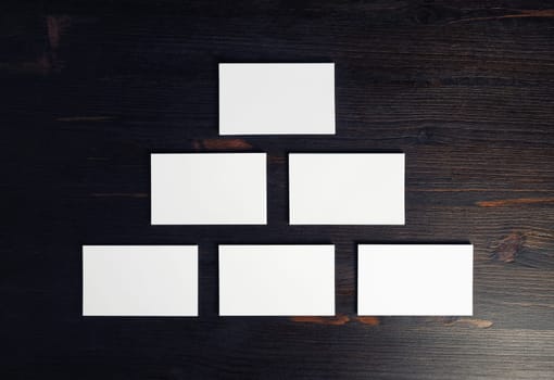 Blank business cards on wood table background. Mockup for branding identity. Flat lay.
