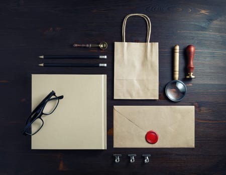 Blank kraft stationery set on wooden background. Template for branding identity. For graphic designers presentations and portfolios. Flat lay.