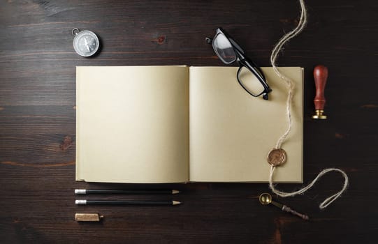 Blank kraft paper book and vintage stationery set on wooden background. Copy space for text. Flat lay.