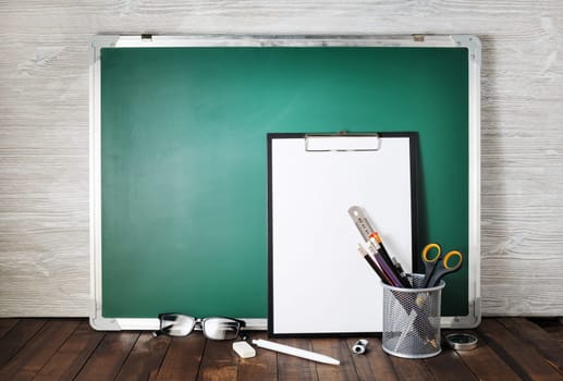 Photo of blank green blackboard and stationery. School supplies. Responsive design template.