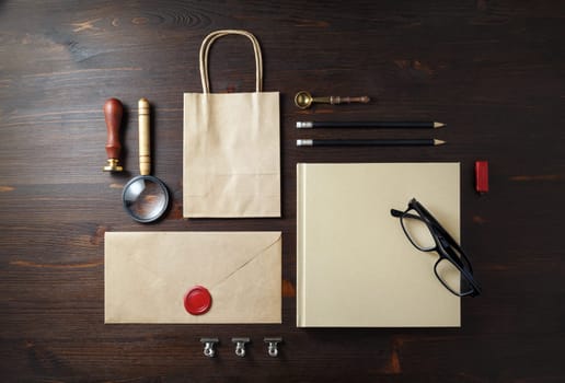 Blank kraft paper stationery on wooden background. Branding mock-up. Flat lay.
