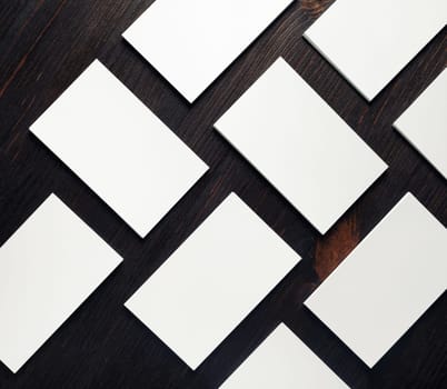 Blank white business cards on wood table background. Mockup for branding identity. Copy space for text. Flat lay.