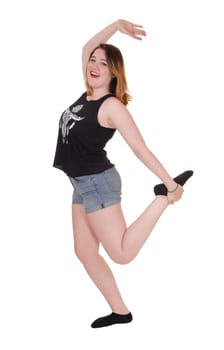 A pretty woman dancing in the studio is jeans shorts with her.hands raised and singing, isolated for white background.