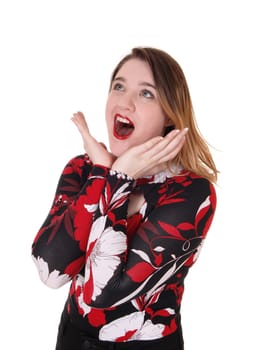 A young screaming woman in a close up image with her mouths open.and her hands on her face, isolated for white background.