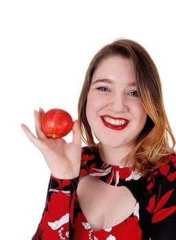 Happy young woman in a colorful blouse and brunette hair smiling and.holding up a red apple for healthy living, isolated for white background.