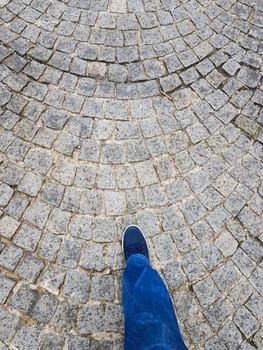 Picture taken up to down of foot on a paved floor