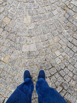 Picture taken up to down of foot on a paved floor