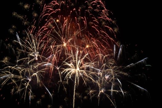 Red colorful holiday fireworks on the black sky background.
