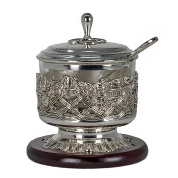 Sugar bowl of silver metal with glass insert and spoon. Isolated on white