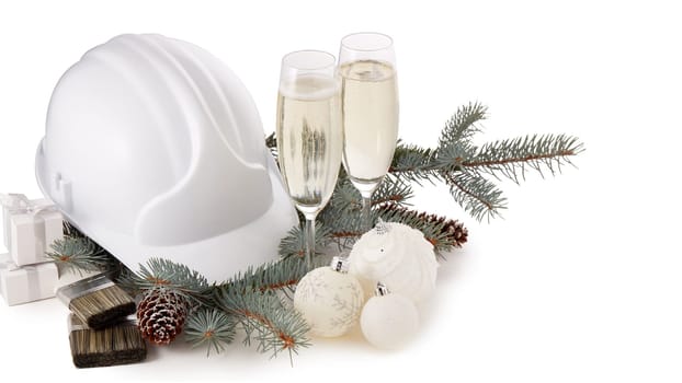 Construction hard hat, fir tree branches, two glasses with champagne, gift boxes and Christmas ornament isolated on a white background. New Year and Christmas construction background