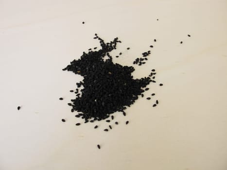 Black caraway seeds on a wooden board