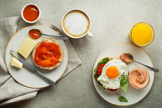 Breakfast served with orange juice, sandwich with egg, jam with butter and coffee. Delicious healthy breakfast.