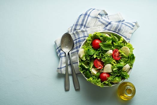 Healthy green salad with tomato and mozzarella cheese. Home made food. Concept for a tasty and healthy meal