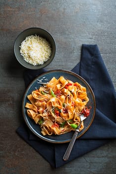 Tasty appetizing classic italian pasta with tomato sauce, cheese parmesan and basil on plate. View from above