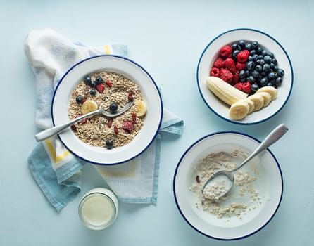 Eating porridge oatmeal with fruits, berries, and honey. Concept of healthy breakfast, wellbeing, healthy eating, dieting and weight loss