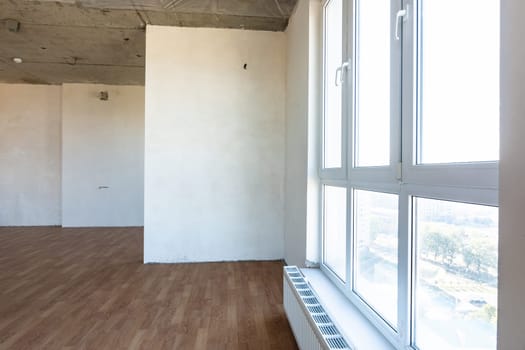 Large stained glass window and battery in the interior of an empty room of a new building
