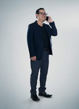 Happy smiling businessman wearing black suit and using modern smartphone